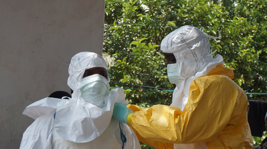 Het aantrekken van beschermingspakken tegen het Ebola-virus in Sierra Leone